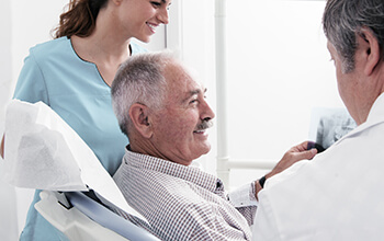 patient with dentist and dental assistant