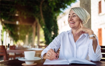 person drinking coffee and writing