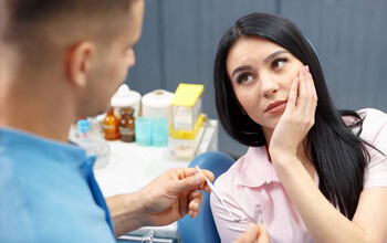 Woman holding cheek in pain