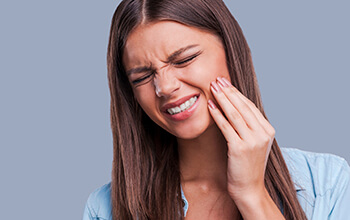 girl in blue shirt having toothache