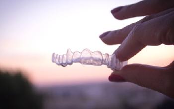 Hand holding a clear aligner